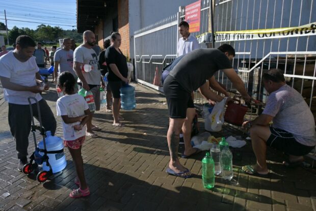 Brazilians queue for precious water as flood damage intensifies