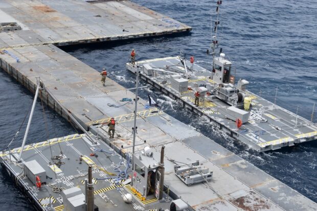 This handout picture courtesy of the US Central Command (CENTCOM) taken on April 26, 2024 shows construction work on the floating JLOTS pier in the Mediterranean Sea, 