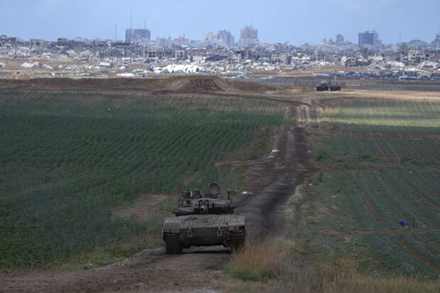 An Israeli Defense Forces tank drives away from the Gaza Strip
