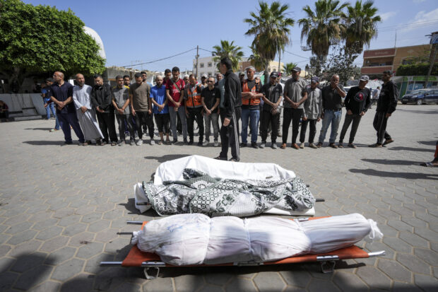 Palestinians prayer next to the bodies of their relatives who were killed in an Israeli airstrike in Gaza Strip