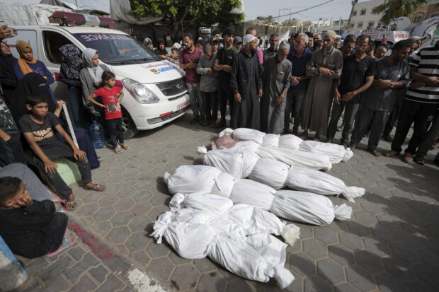 Palestinians pray next to the bodies of their relatives killed in an Israeli bombardment of the Gaza Strip