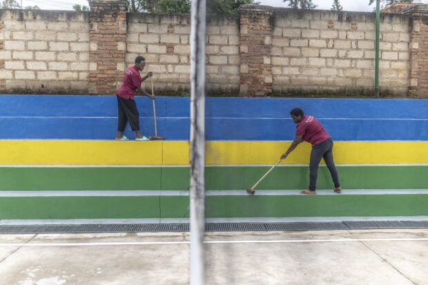 Workers clean the stairs next to a volleyball court at Hope Hostel, which is getting ready to welcome the migrants from the United Kingdom (UK