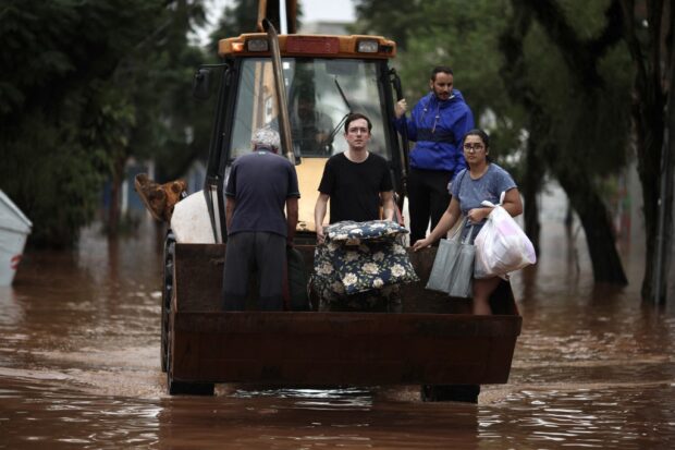 People are evacuated from a flooded area on a skid steer loader in the São Geraldo neighborhood in Porto Alegre, Rio Grande do Sul State, Brazil, on May 4, 2024. 