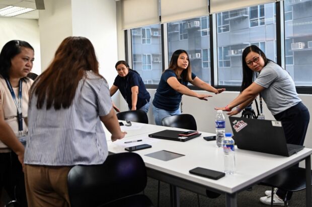 In this photo taken on December 12, 2023, shows employees conduct a breast self-check examination during a seminar on breast cancer awareness