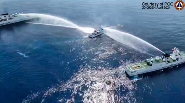 PHOTO; This frame grab from handout video footage taken and released on April 30, 2024, by the Philippine Coast Guard (PCG) shows the Philippine Coast Guard ship BRP Bagacay (C) being hit by water cannons from Chinese Coast Guard vessels near the Chinese-controlled Scarborough shoal in disputed waters of the South China Sea. STORY: PH-China relations ‘a bit choppy’ amid maritime dispute, says Manalo