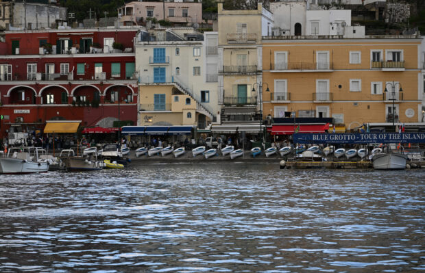 This photograph taken on April 20, 2024, shows a view of buildings and boats on the shores of the island of Capri. (Photo by Tiziana FABI / AFP)