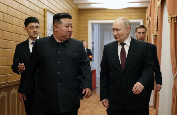 In this pool photograph distributed by the Russian state agency Sputnik, North Korea's leader Kim Jong Un (L) walks with Russian President Vladimir Putin shortly after Putin's arrival in Pyongyang, early on June 19, 2024. Russian President Vladimir Putin landed in North Korea early on June 19, the Kremlin said, kicking off a visit set to boost defence ties between the two nuclear-armed countries as Moscow pursues its war in Ukraine.