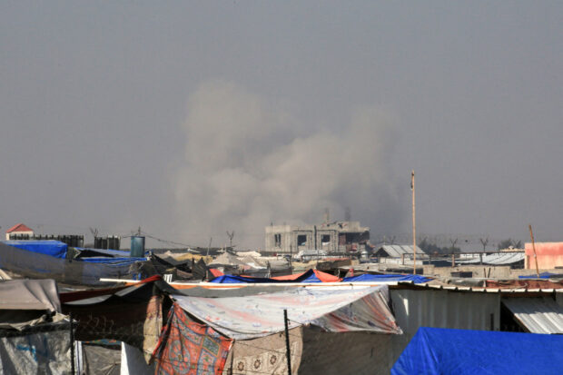 Smoke from Israeli bombardment billows in Rafah in the background as seen from a camp for displaced people in Khan Yunis on June 21, 2024, in the southern Gaza Strip, amid the ongoing conflict in the Palestinian territory between Israel and Hamas. (Photo by Eyad BABA / AFP)