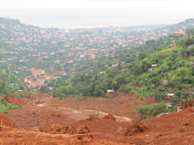 Residents watch the rescue operations at the side of a mud slide in the Sierra Leone capital Freetown on August 15, 2017. Sierra Leone's president appealed for urgent help for the flood-hit capital of Freetown where more than 300 people have died, as rescue workers resumed the grim search for bodies.Mohamed Saidu BAH / AFP