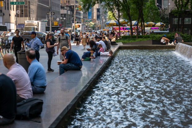 People rest next to a fountain in midtown Manhattan as much of the Northeast brace for a heat wave on June 18, 2024 in New York City. Temperatures are forecasted to soar into the high 90s, with a heat index surpassing 100 degrees.   Spencer Platt/Getty Images/AFP (Photo by SPENCER PLATT / GETTY IMAGES NORTH AMERICA / Getty Images via AFP)