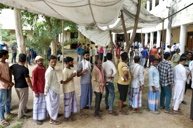 Voters queue up to cast their ballots at a polling station in Varanasi on June 1, 2024, during the seventh and final phase of voting in India's general election.