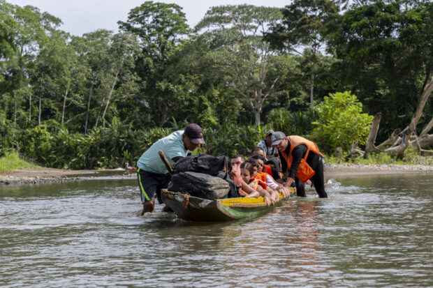 Migrants are transported by boat from Bajo Chiquito, the first border checkpoint in Panama's Darien province, to the Migrants Reception Station in Lajas Blancas on September 21, 2023. The clandestine journey through the Darien Gap usually lasts five or six days, at the mercy of all kinds of bad weather. More than 390,000 migrants have entered Panama through this jungle so far this year, far more than in all of 2022, when there were 248,000, according to official Panamanian data. (Photo by Luis ACOSTA / AFP)