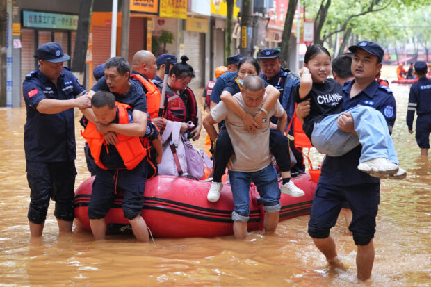 Rescue workers evacuate flood-affected residents following heavy rains in Yueyang, in central China's Hunan province on July 2, 2024. (Photo by CNS / AFP) 