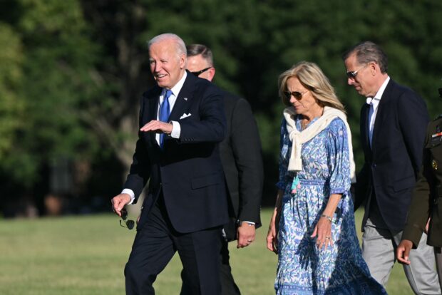 US President Joe Biden waves as he walks with First Lady Jill Biden and son Hunter Biden upon arrival at Fort McNair in Washington, DC, on July 1, 2024. Biden returned to Washington for the first time after the first presidential debate in Atlanta on June 27. (Photo by Mandel NGAN / AFP)