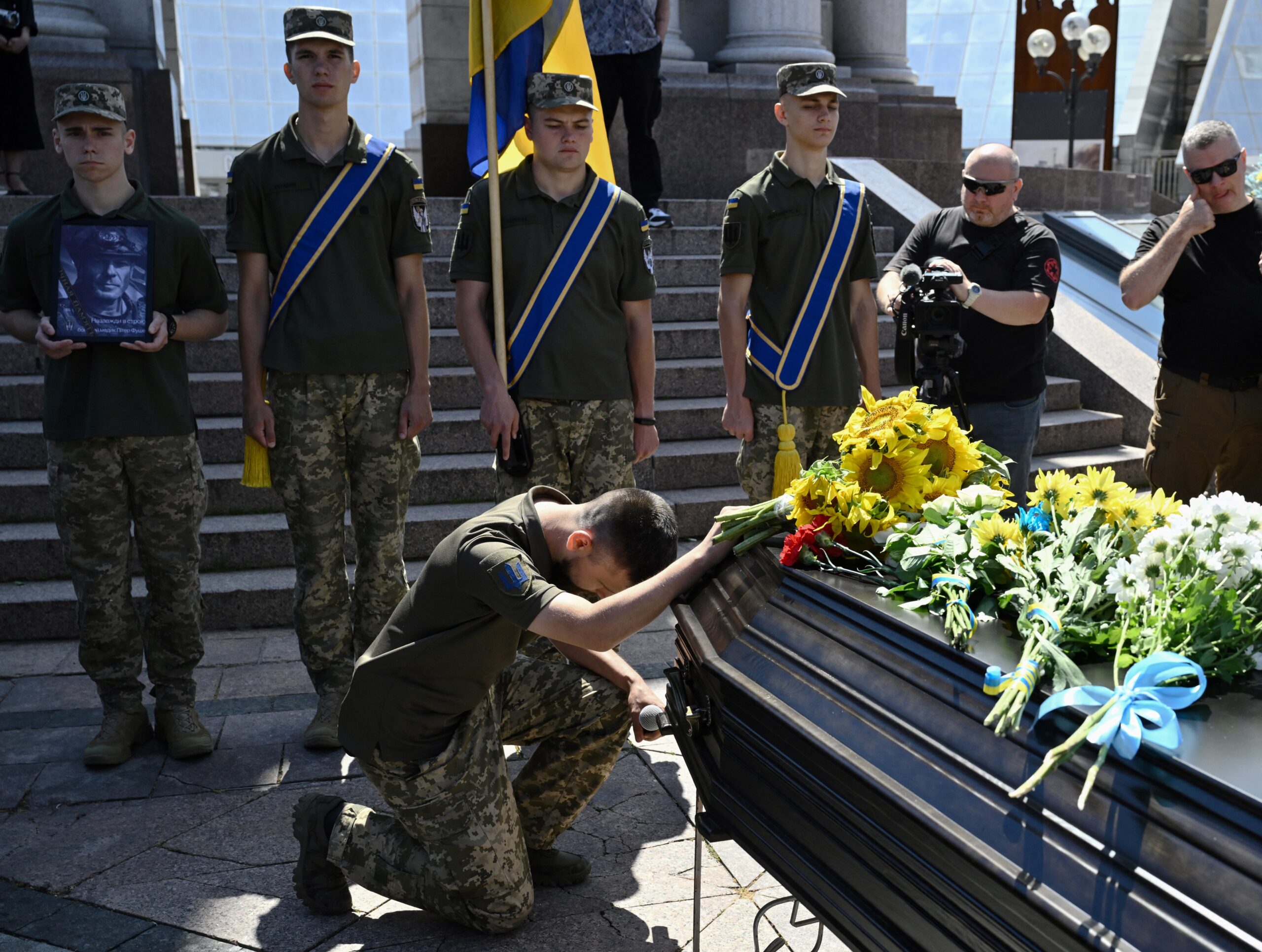 A comrade pays his respects next to the coffin containing the body of Peter Fouché