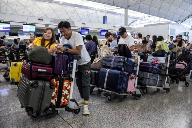 Passengers wait to be checked-in at Hong Kong International Airport on July 19, 2024, as some airlines resort to manual check-in due to a world wide Microsoft outage. (AFP)