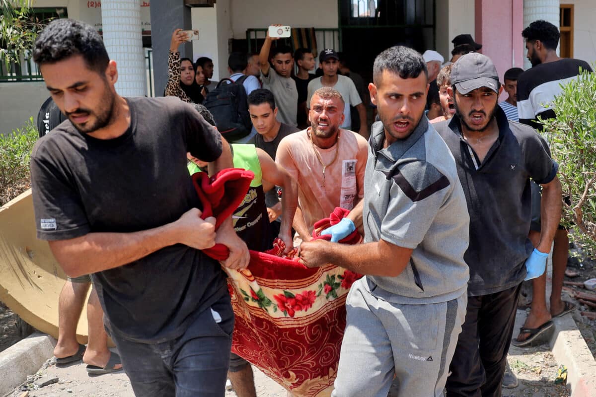 People carry a person injured during an Israeli strike on the Khadija school housing displaced people in Deir al-Balah, in the central Gaza Strip on July 27, 2024, amid the ongoing conflict between Israel and the militant Hamas group. The health ministry in Hamas-run Gaza said an Israeli strike on July 27 on a school killed 30 people, after a days-long military operation further south left around 170 dead, according to the civil defence agency. Israel's military said it carried out a strike on the school targeting "terrorists" operating there. (Photo by Eyad BABA / AFP)