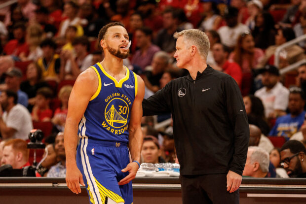 Head coach Steve Kerr of the Golden State Warriors greets Stephen Curry #30 in the second half against the Houston Rockets at Toyota Center on October 29, 2023 in Houston, Texas.