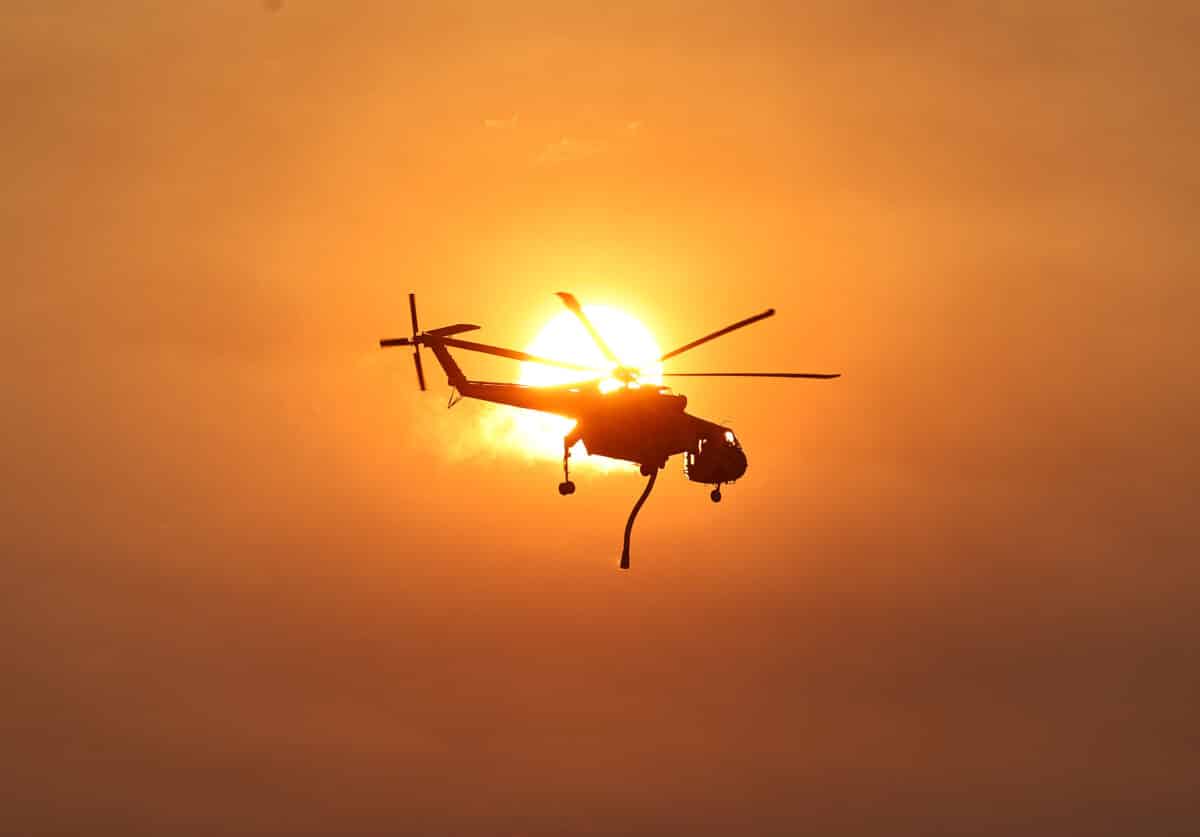 A firefighting helicopter flies as the Lake Fire burns in Los Padres National Forest with evacuation warnings in the area on July 6, 2024 near Los Olivos, California. The wildfire in Santa Barbara County has scorched over 13,000 acres amid a long-duration heat wave which is impacting much of California.