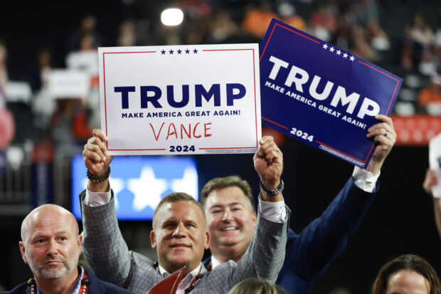 People hold signs endorsing Republican presidential candidate, former U.S. President Donald Trump along with his pick for Vice President, U.S. Sen. J.D. Vance's (R-OH) name written on it on the first day of the Republican National Convention at the Fiserv Forum on July 15, 2024 in Milwaukee, Wisconsin. Delegates, politicians, and the Republican faithful are in Milwaukee for the annual convention, concluding with former President Donald Trump accepting his party's presidential nomination. The RNC takes place from July 15-18. 