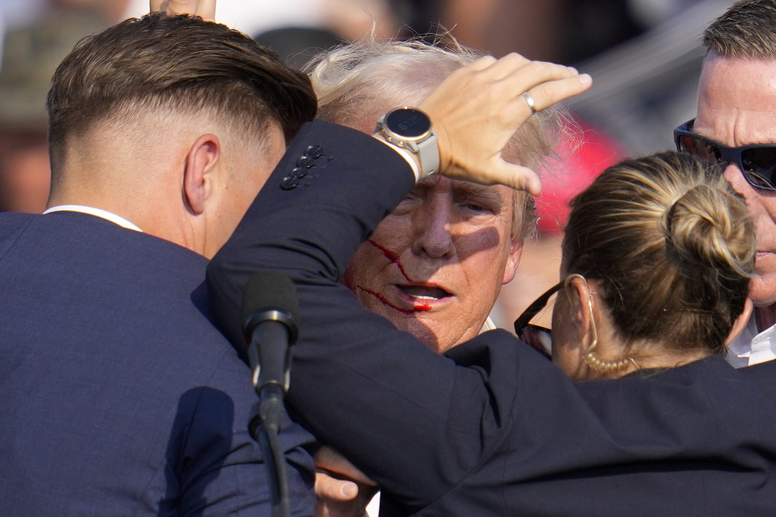 Republican presidential candidate former President Donald Trump is helped off the stage by U.S. Secret Service agents at a campaign event in Butler, Pa., on Saturday, July 13, 2024.