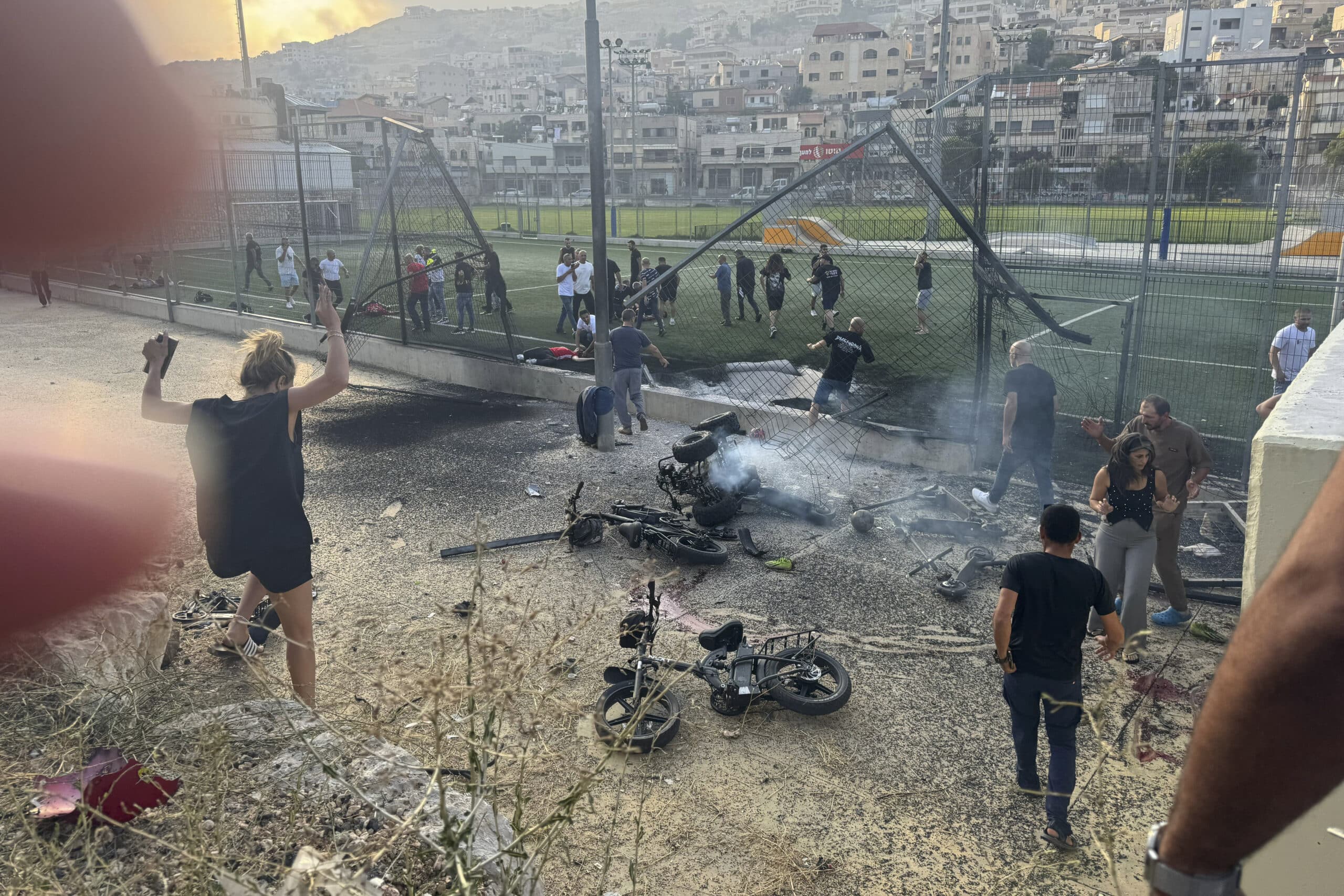 Residents rush to help injured children moments after a rocket attack hit a soccer field in the Druze town of Majdal Shams in the Israeli-controlled Golan Heights.