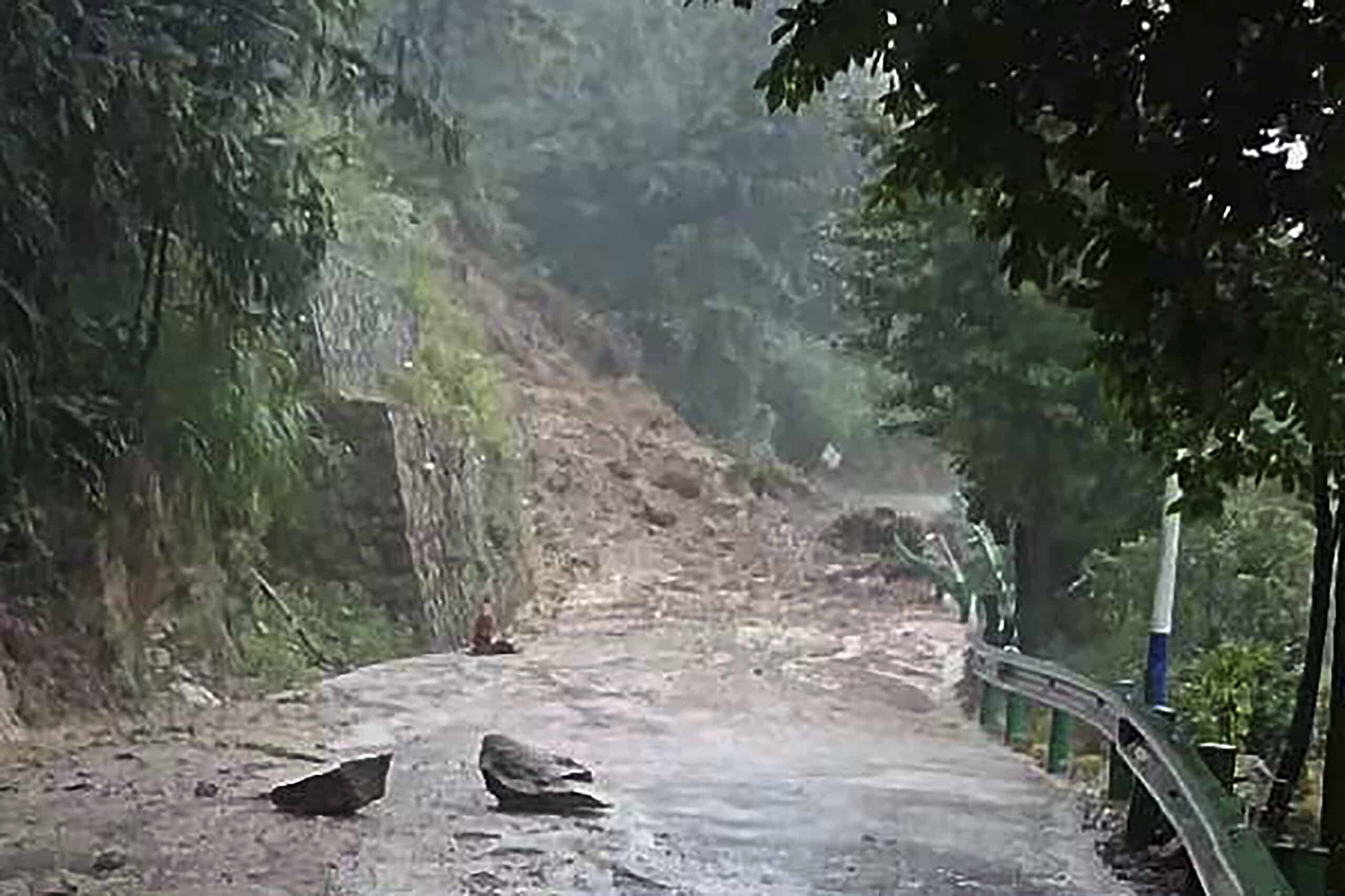 In this photo released by Xinhua News Agency, a landslide blocks a road in Shouyue Town of Nanyue District, Hengyang City, central China's Hunan Province 