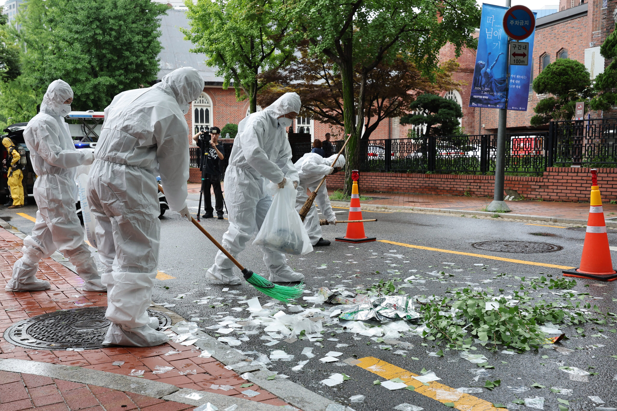 South Korean officials clean up the contents of a trash-carrying balloon sent by North Korea after it landed on a street in Seoul on July 24, 2024. 