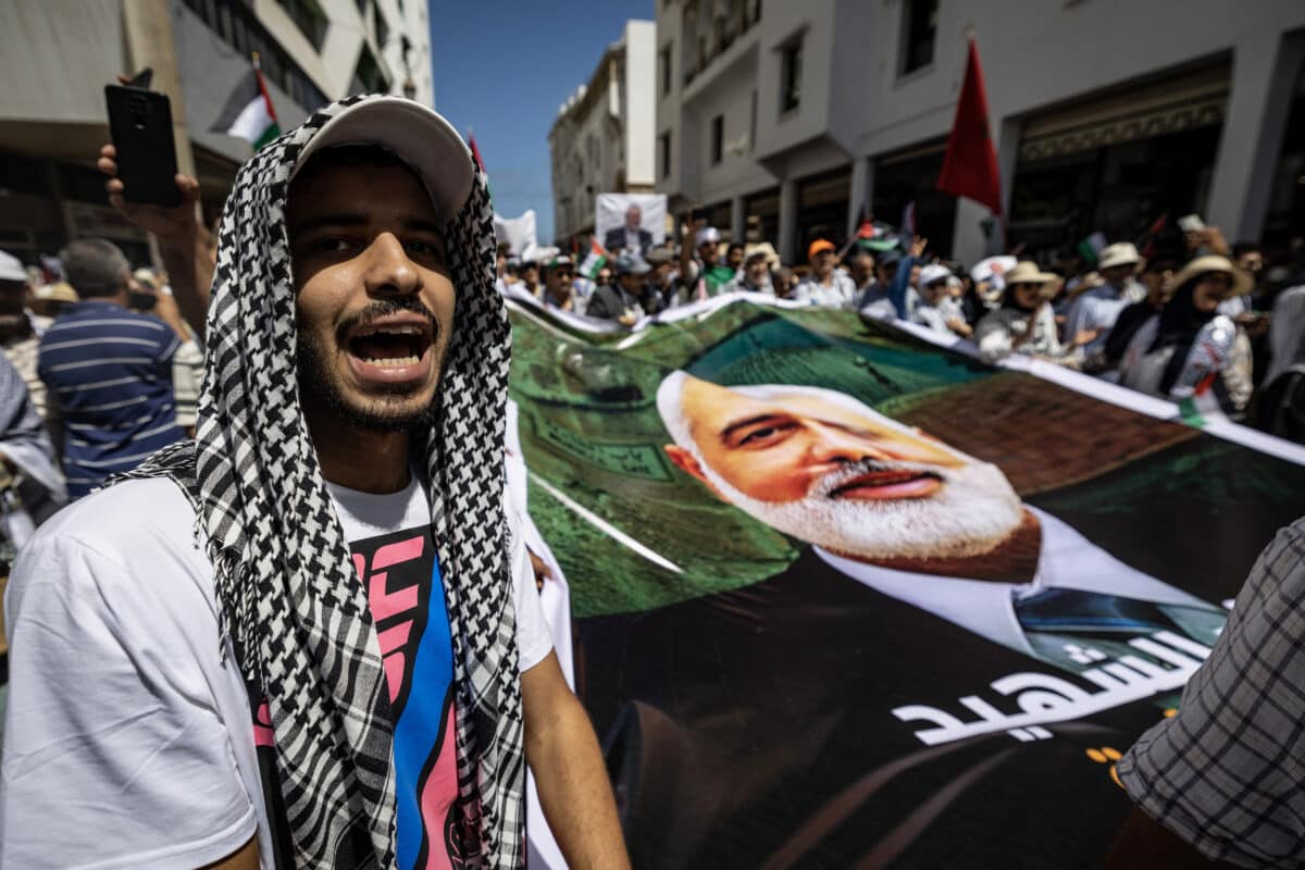 Demonstrators lift placards and flags of Palestine during a rally in Rabat on August 3, 2024, protesting the killing of Palestinian militant group Hamas leader Ismail Haniyeh (portrait). (Photo by FADEL SENNA / AFP)