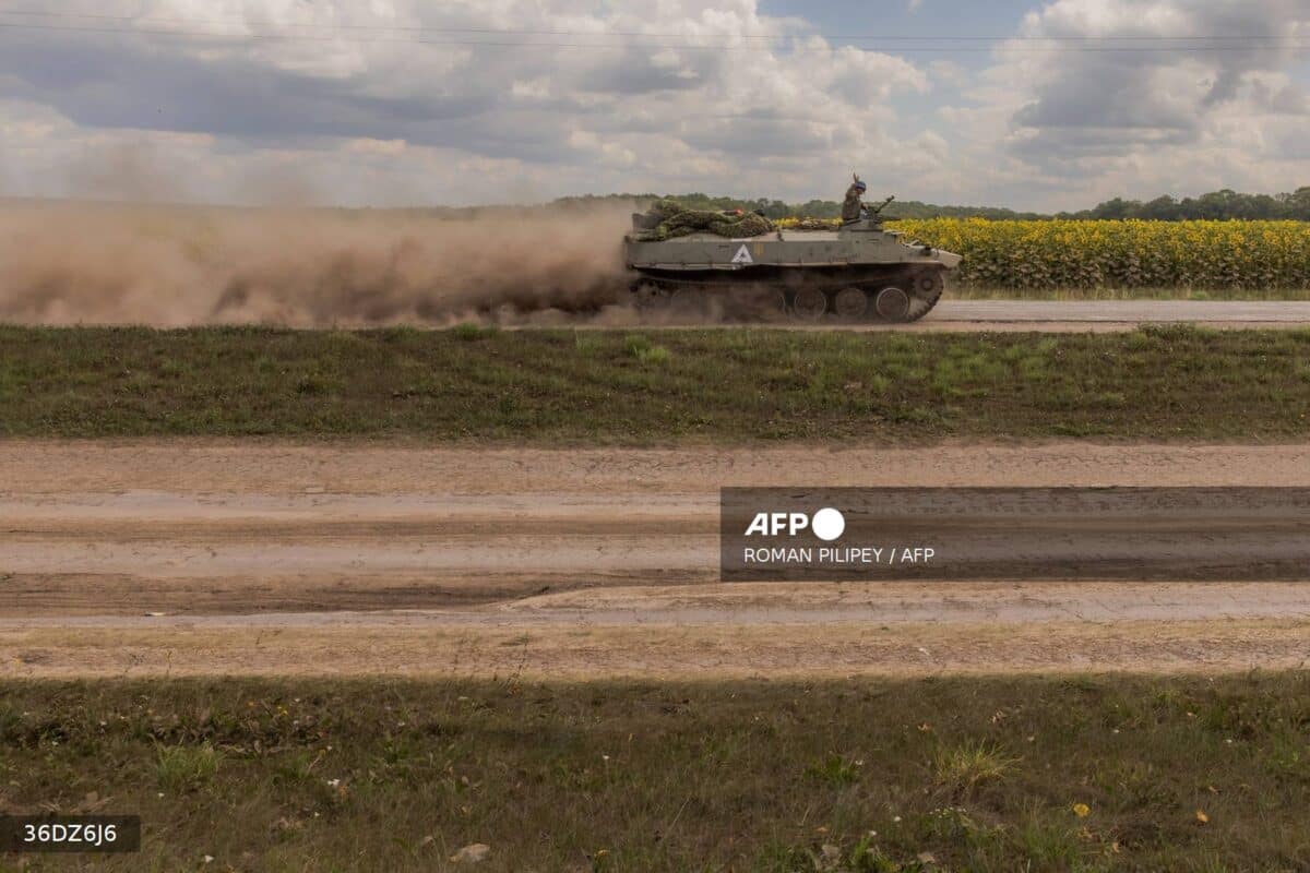 Ukrainian servicemen ride a Soviet-made armored fighting vehicle MT-LB psat fields of sunflowers in the Sumy region, near the border with Russia.