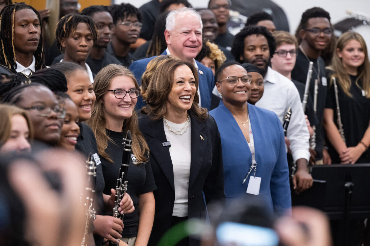 Democratic presidential candidate US Vice President Kamala Harris and her running mate, Governor Tim Walz, pose with members of the marching band during a visit at Liberty County High School in Hinesville, Georgia,  August 28, 2024, as they travel across Georgia for a 2-day campaign bus tour. 