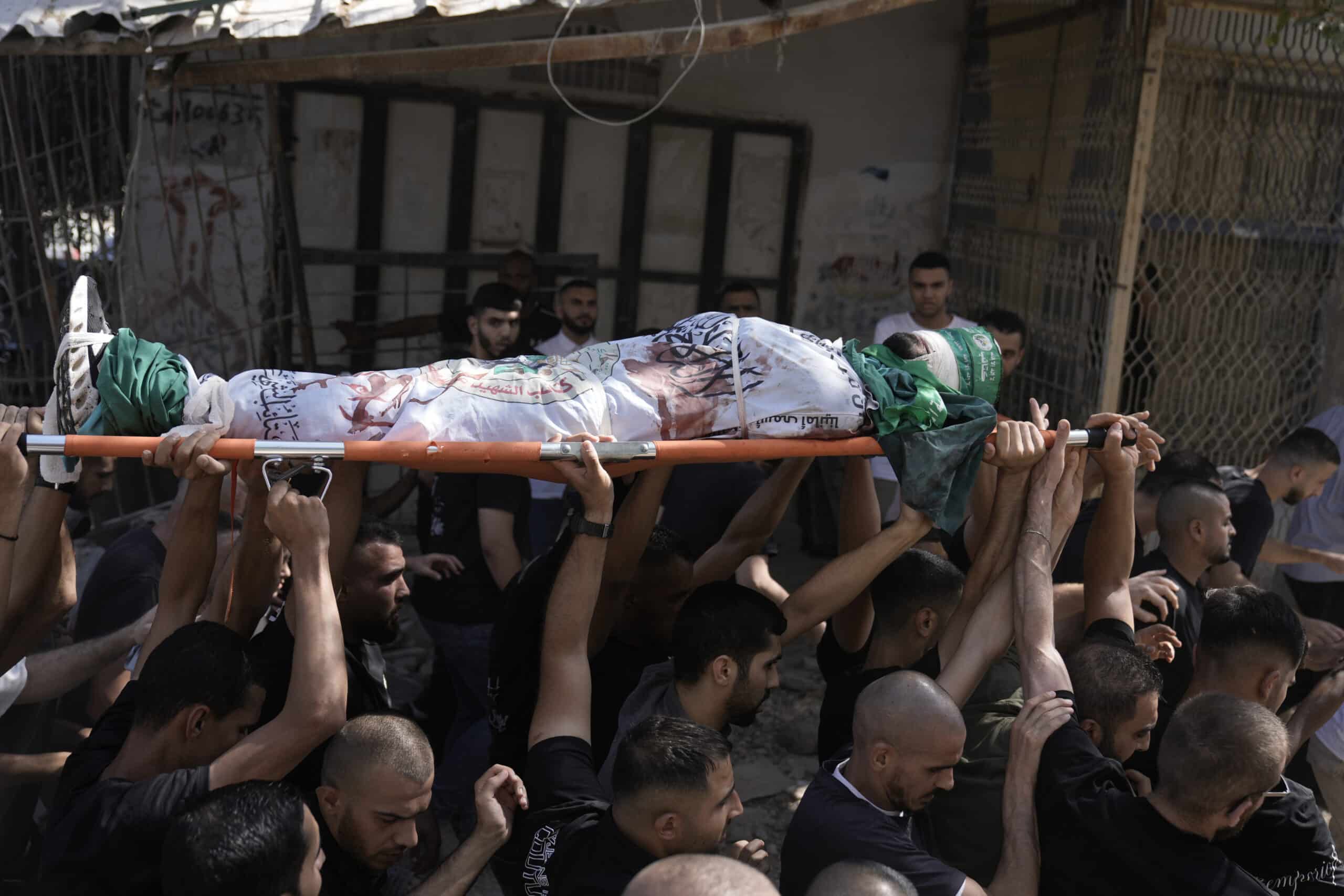 Mourners carry the body of militant Haitham Balidi, draped in the Qassam Brigade flag of the Hamas militant group's military wing, in Tulkarem refugee camp in the West Bank, Saturday, Aug. 3, 2024. 