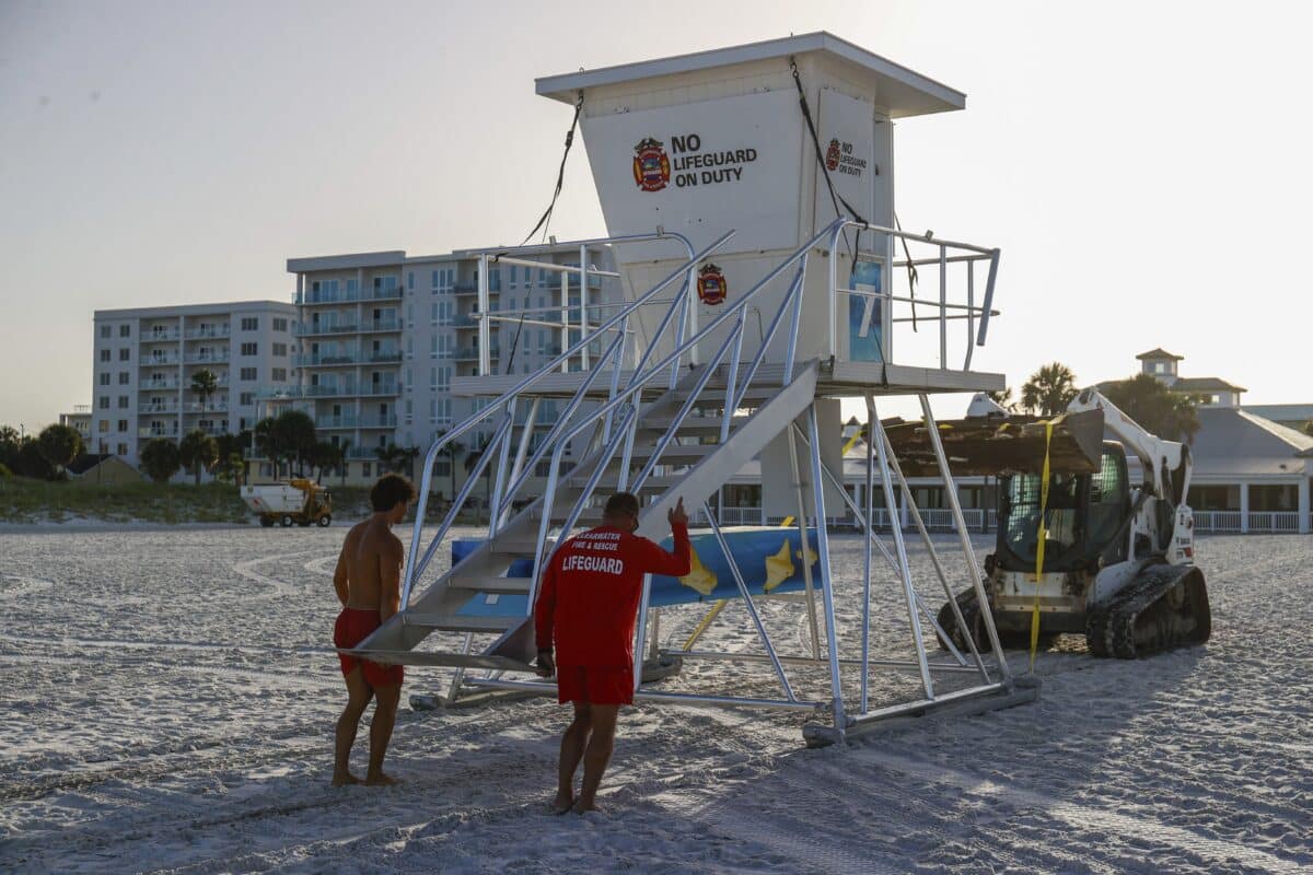 From left, Matthew Blowers and Patrick Brafford prepare to secure a lifeguard tower in preparation of potential storm at Clearwater Beach on Saturday, Aug. 3, 2024, in Clearwater, Fla. 