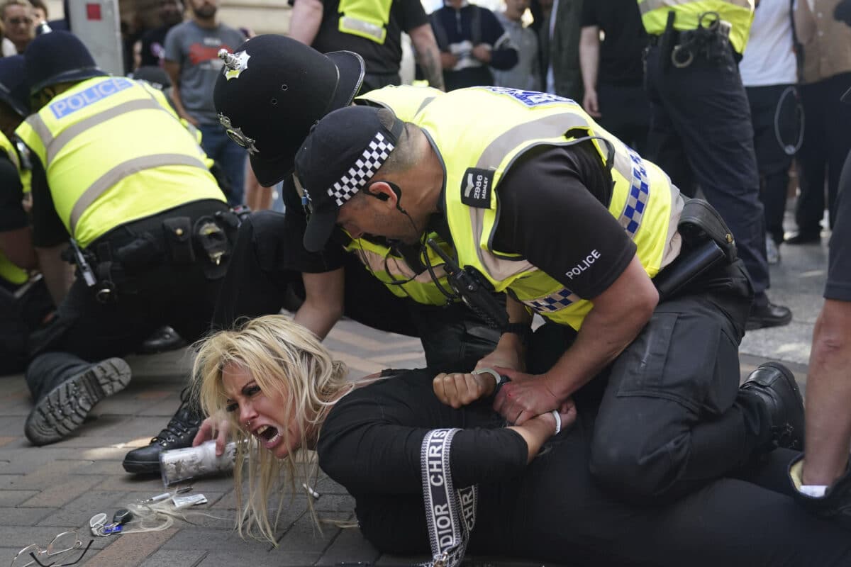 Police officers detain a woman during a protest in Nottingham, England's Market Square Saturday Aug. 3, 2024, 