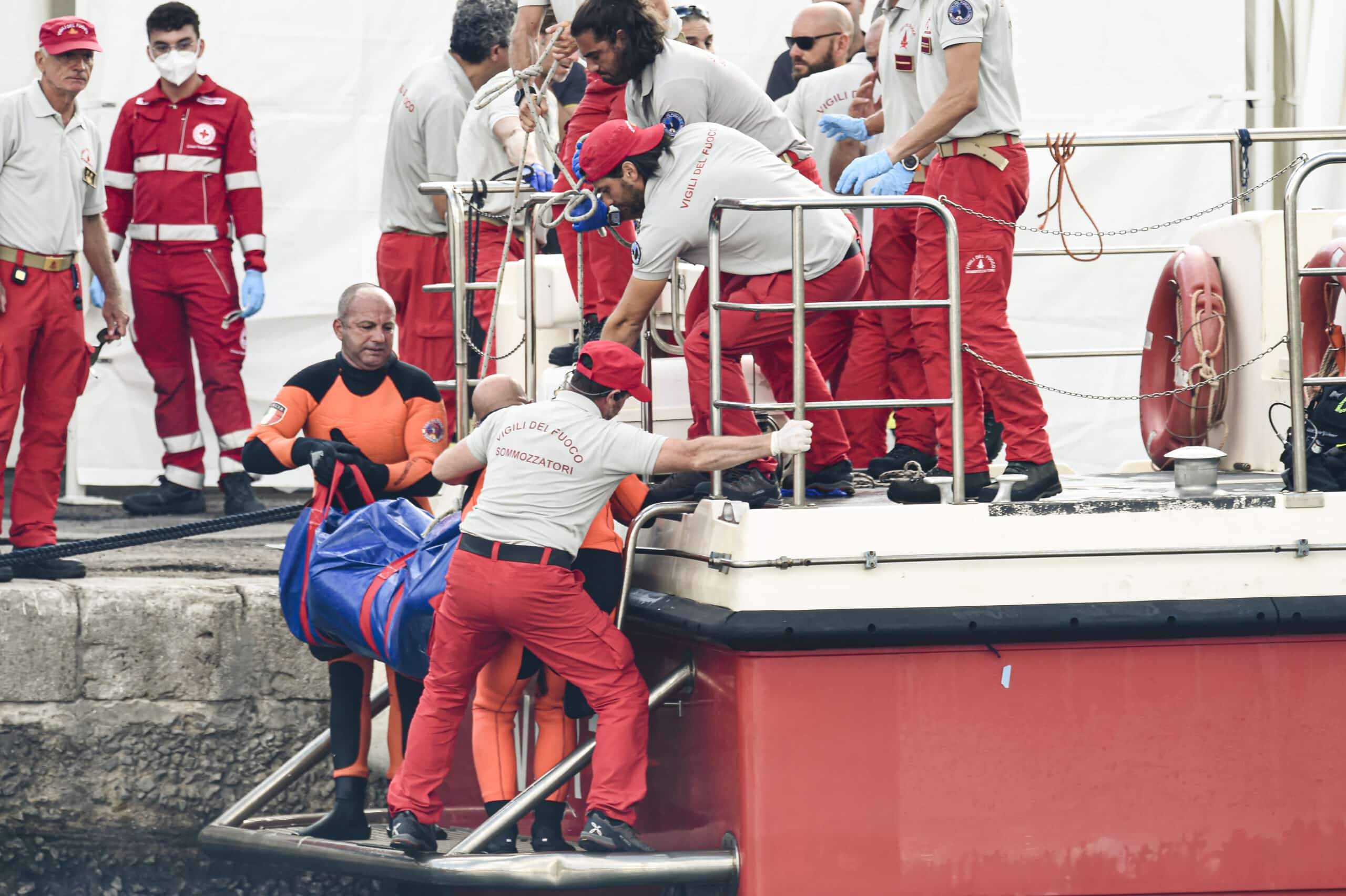 Italian firefighter divers bring ashore in a plastic bag the body of one of the victims of a shipwreck, in Porticello, Sicily, southern Italy, Thursday, Aug. 22, 2024. Divers searching the wreck of the superyacht Bayesian that sank off Sicily on Monday recovered a fifth body on Thursday and continued to search for one more as investigators sought to learn why the vessel sank so quickly. (AP Photo/Salvatore Cavalli)