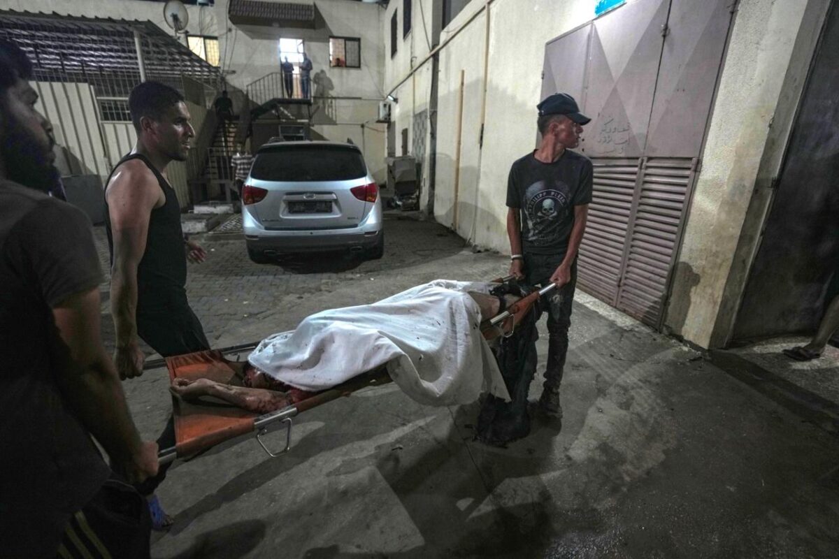 Palestinians carry the body of a victim of an Israeli strike that hit a tent area in the courtyard of Al Aqsa Martyrs hospital in Deir al Balah, Gaza Strip, Sunday, Aug. 4, 2024. The strike killed several people including a woman and injured others, health officials confirmed. 