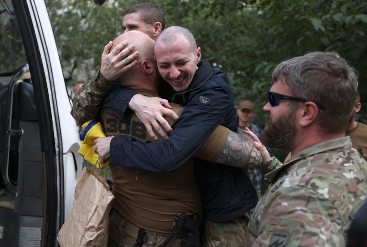 Ukrainian servicemen of the 12th Special Forces Brigade "Azov" of the National Guard of Ukraine embrace fellow soldiers after being released from Russian captivity at an undisclosed location near the Ukrainian-Belarusian border, on September 13, 2024, amid the Russian invasion in Ukraine. - 49 Ukrainian prisoners of war, including soldiers of the armed forces of Ukraine, the National Guard, the national police, the state border guard service, as well as fighters from Mariupol's 2022 Azvostal battle, had been returned to their country from Russia on September 13, 2024.