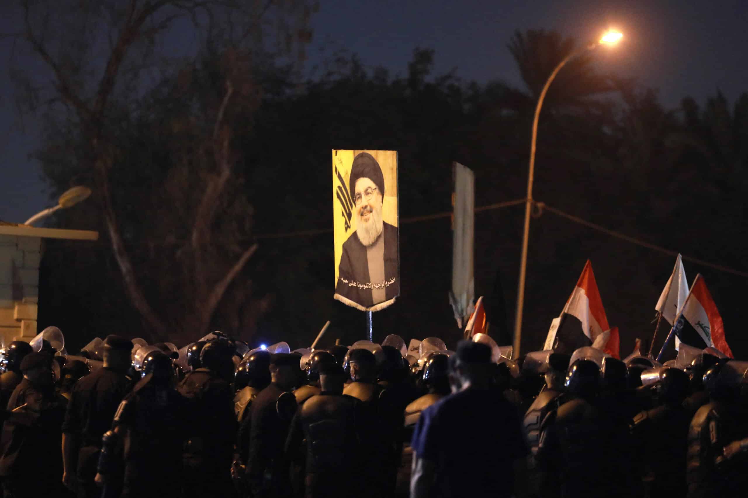 An Iraqi demonstrator holds a picture of Hassan Nasrallah, late leader of the Lebanese group Hezbollah, during a protest vigil near the suspension bridge leading to Baghdad's Green Zone on September 28, 2024. - Lebanon announced three days of mourning for Hassan Nasrallah on September 28, after a huge Israeli air strike in Beirut's southern suburbs the previous day killed the Hezbollah leader. (Photo by MURTAJA LATEEF / AFP)