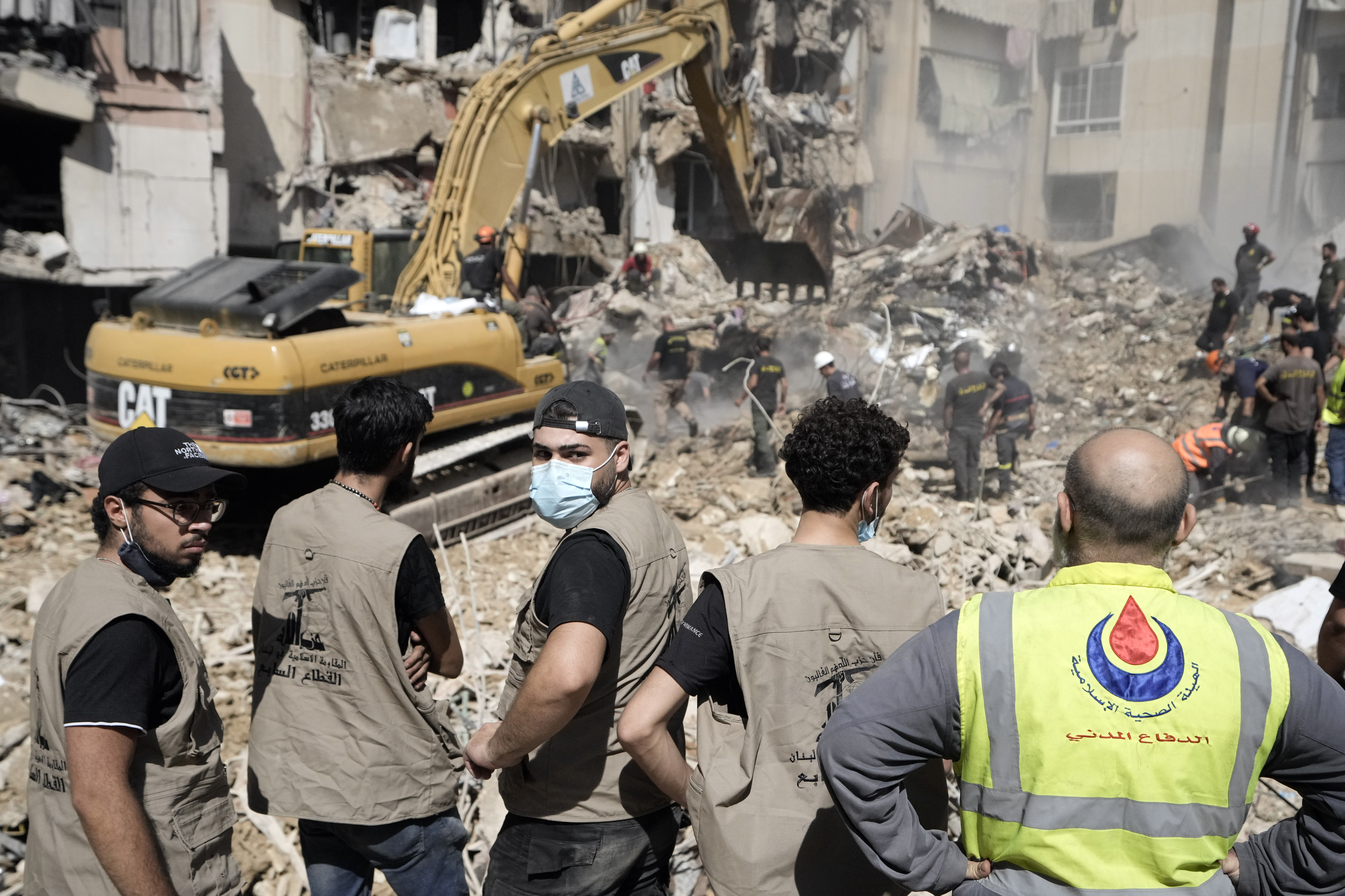 Emergency workers use an excavator to clear the rubble at the site of Friday's Israeli strike in Beirut's southern suburbs, Saturday, Sept. 21, 2024. (AP Photo/Bilal Hussein)