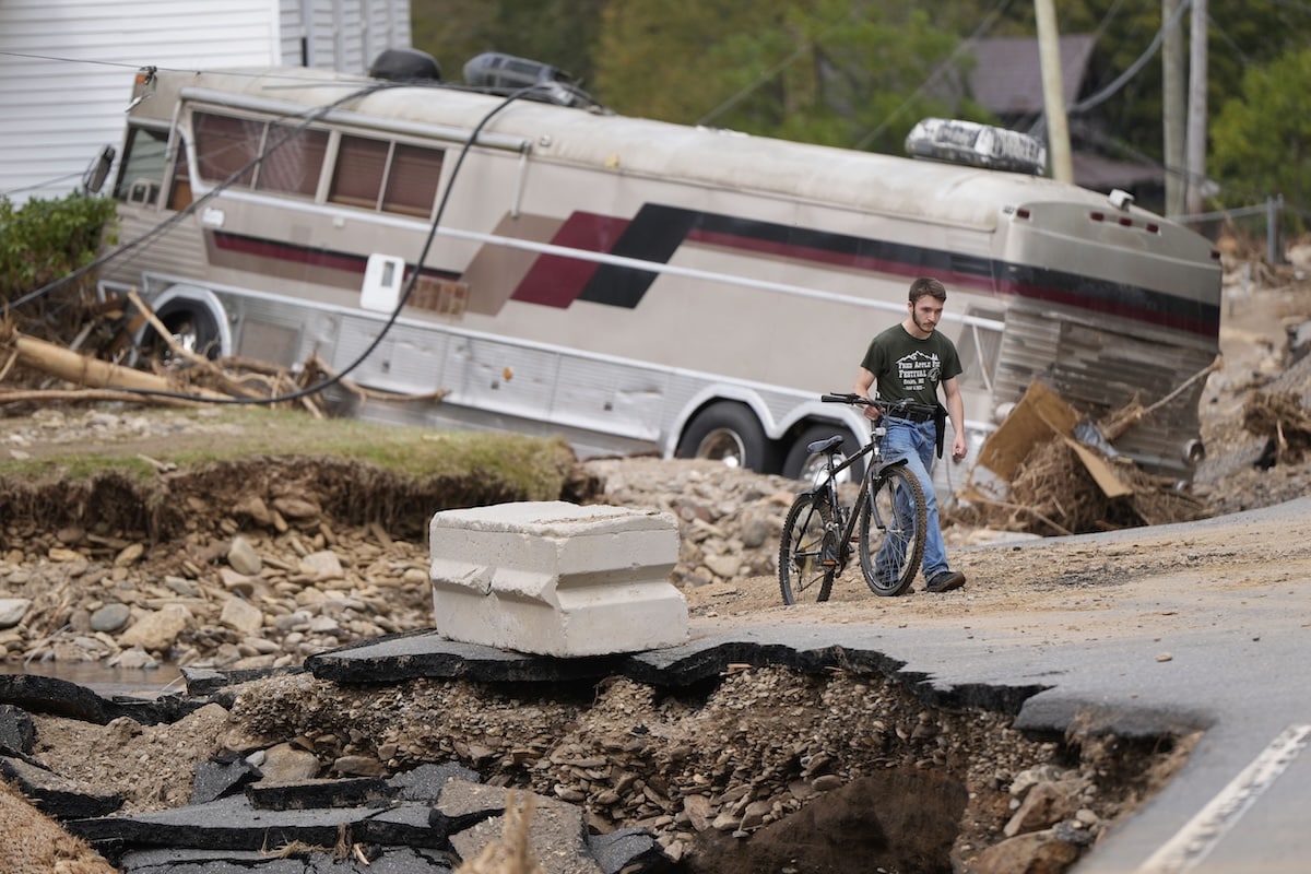 PHOTO: Man with a bikes walks home after Hurricane Helene