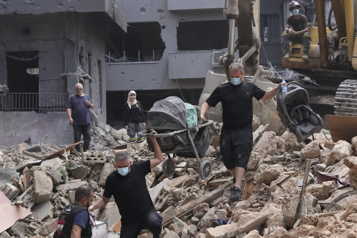 Residents of a building damaged in an Israeli airstrike return to collect their family's belongings at the site of Thursday's Israeli airstrike in Beirut, Lebanon, Saturday, Oct. 12, 2024.