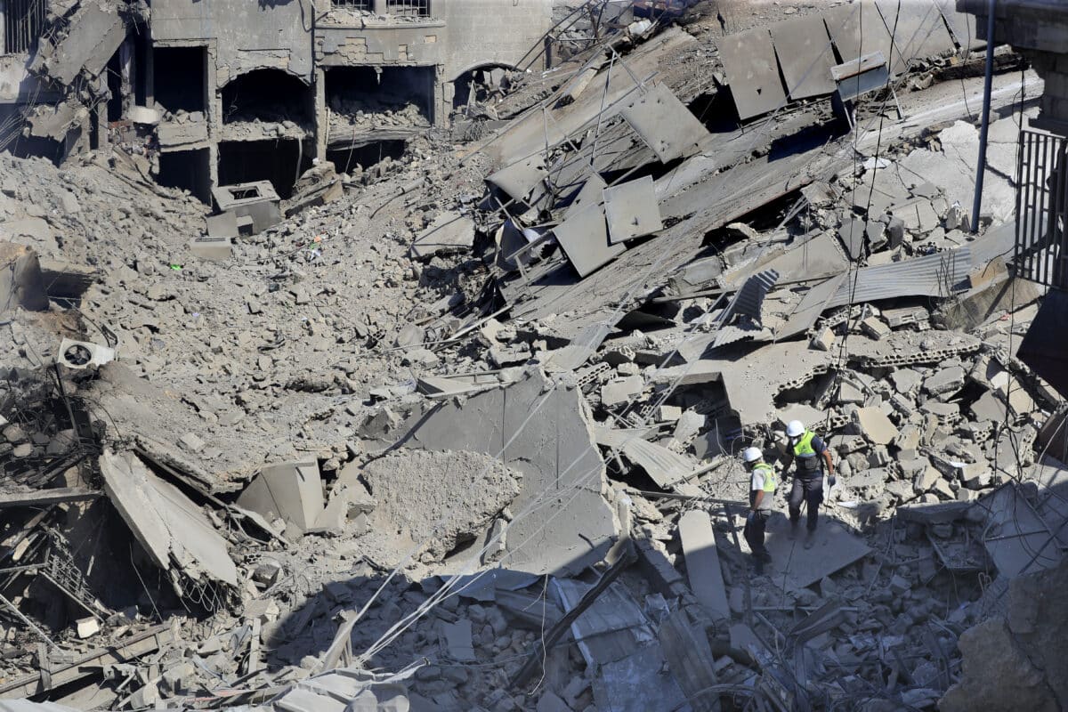 Hezbollah rescue workers search for victims amidst the rubble of destroyed buildings at a commercial street that was hit Saturday night by Israeli airstrikes, in Nabatiyeh town, south Lebanon, Sunday, Oct. 13, 2024