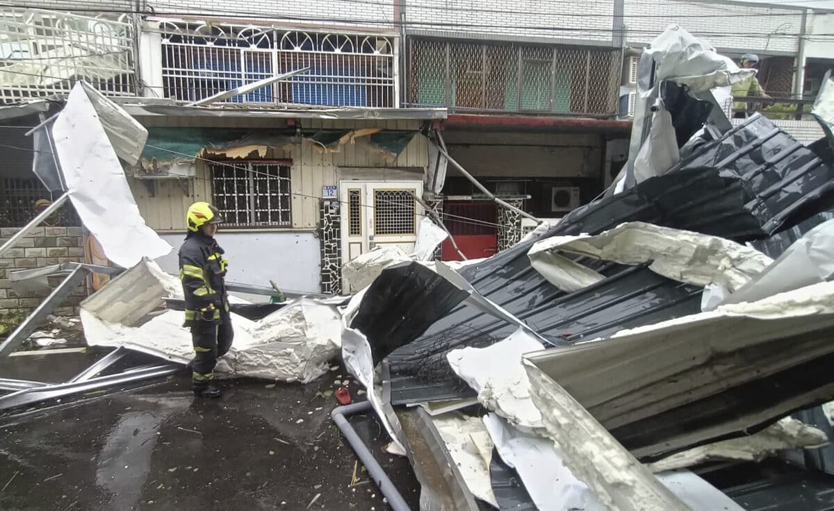 In this photo released by Hualien County Fire Department, police check a blown roof destroyed by the wind of Typhoon Kong-rey in Hualien County, eastern Taiwan, Thursday, Oct. 31, 2024.