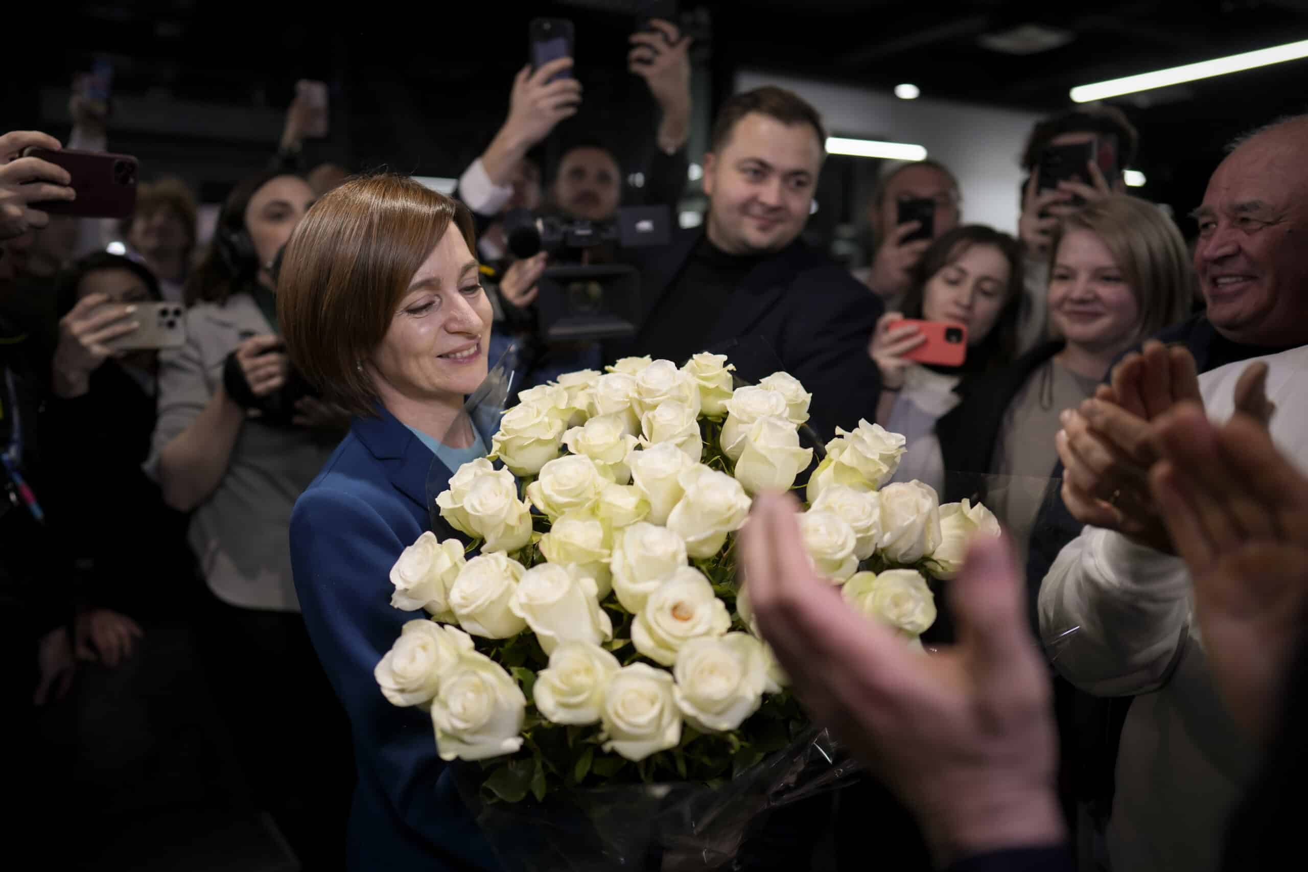 Moldova's President Maia Sandu smiles while holding a bouquet of flowers as she celebrates with supporters the preliminary results of the presidential election runoff, in Chisinau, Moldova, Sunday, Nov. 3, 2024. (AP Photo/Vadim Ghirda)