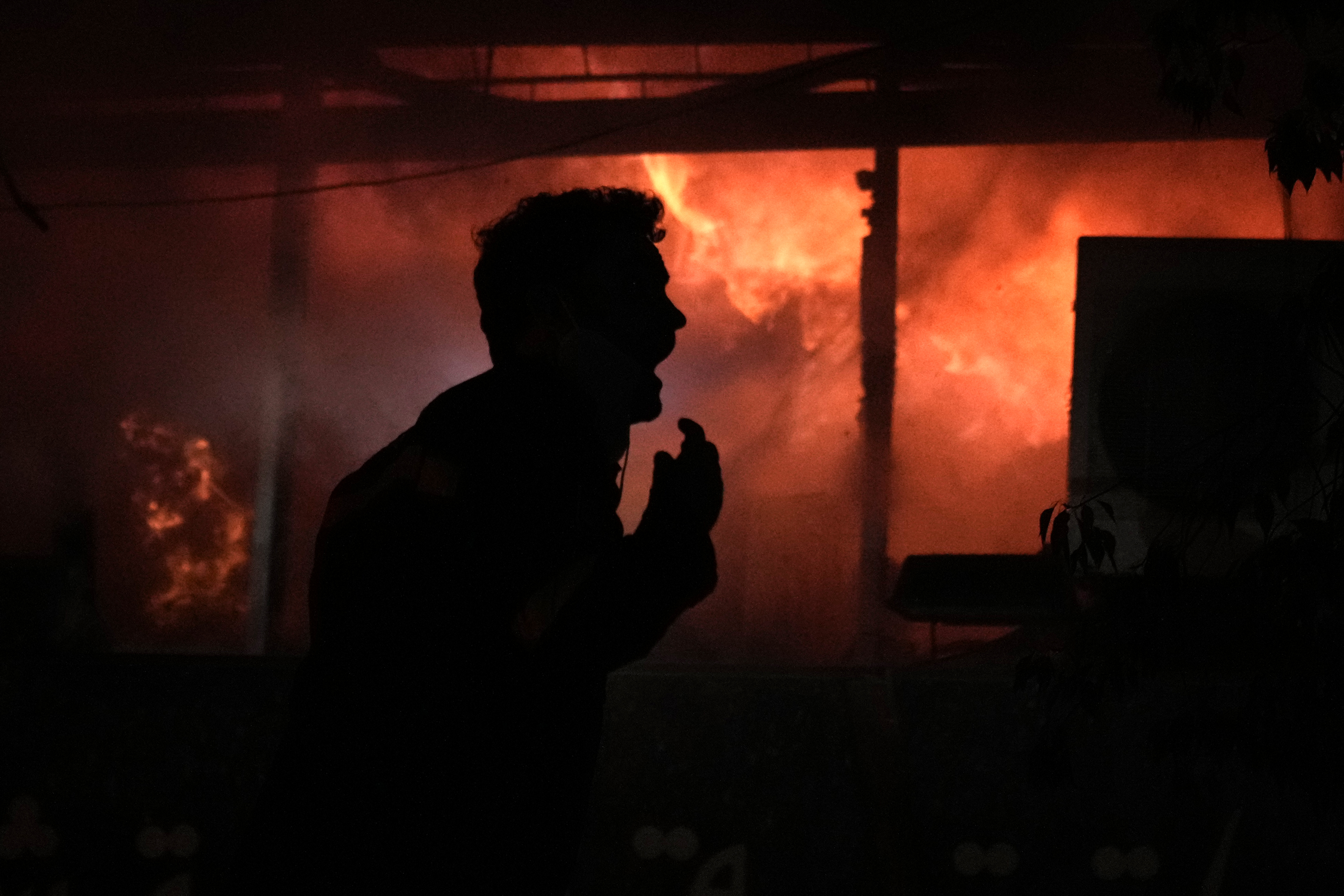 A man screams in front a fire erupting inside a computer shop hit during an Israeli airstrike in central Beirut, Sunday, Nov. 17, 2024.(AP Photo/Bilal Hussein)