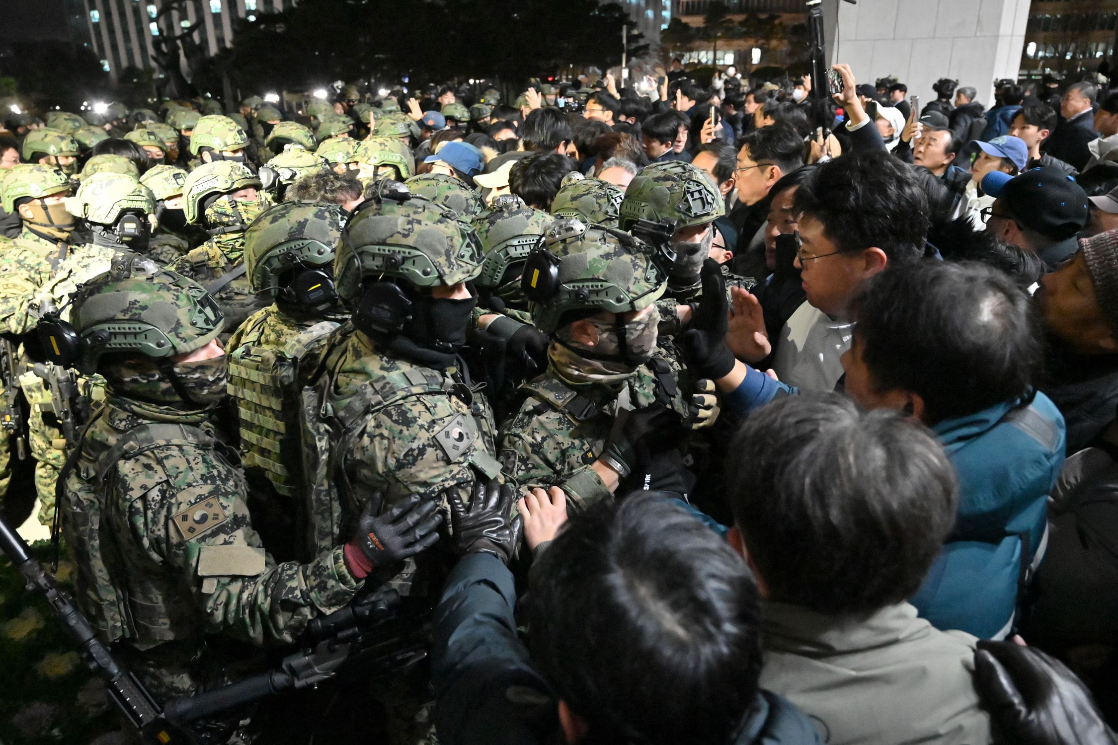 Soldiers try to enter the National Assembly building in Seoul on December 4 2024, after South Korea President Yoon Suk Yeol declared martial law. South Korea's President Yoon Suk Yeol on December 3 declared martial law, accusing the opposition of being "anti-state forces" and saying he was acting to protect the country from "threats" posed by the North.