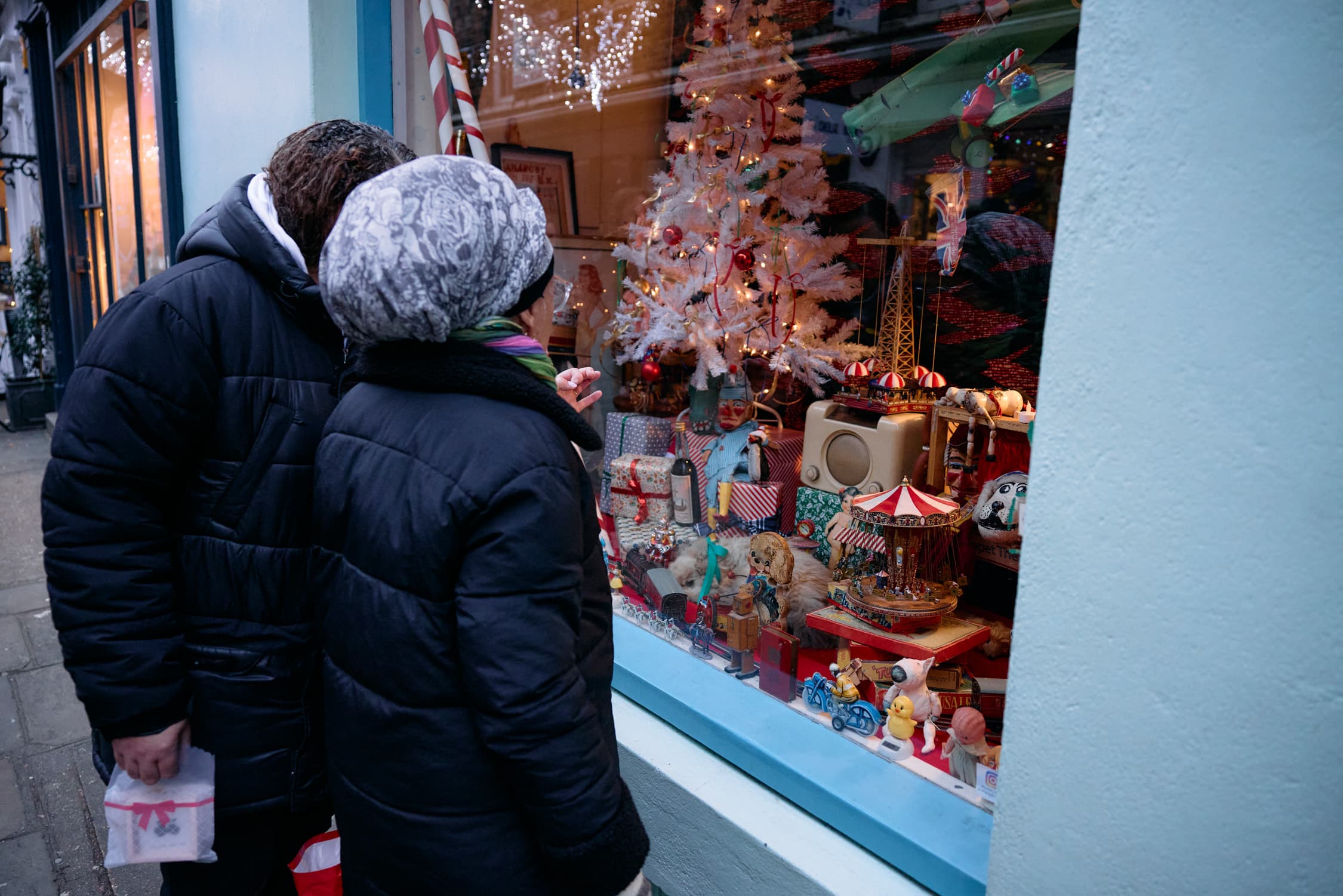 HARD TO MISS Passers-byexamine Christmas items displayed in the window at 43 Camden Passage, owned by Bob Borzello, in London on Dec. 20.