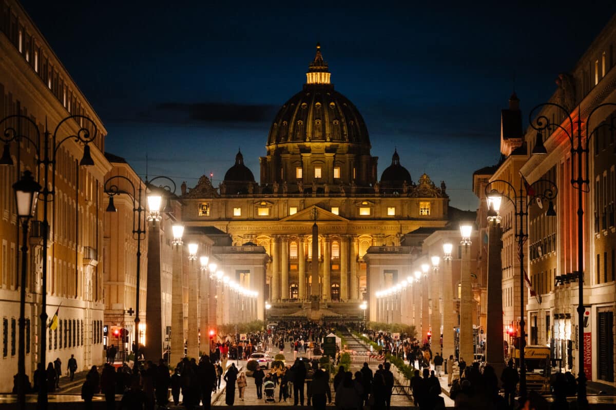 People walk on Via della Conciliazione with St Peter's basilica in the background at sunset in The Vatican on February 27, 2025. Pope Francis's condition was continuing to improve, the Vatican said on February 27, 2025 as the 88-year-old pontiff marked two weeks in hospital with pneumonia in both lungs."The clinical conditions of the Holy Father are confirmed to be improving today also," said the Vatican in an evening bulletin on the pope's health.